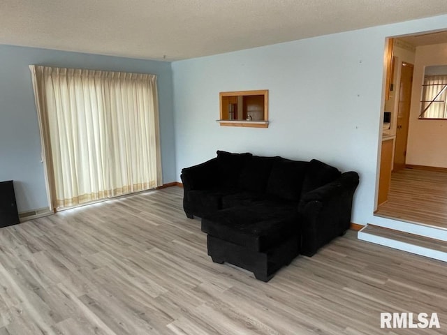 living area with wood finished floors and baseboards