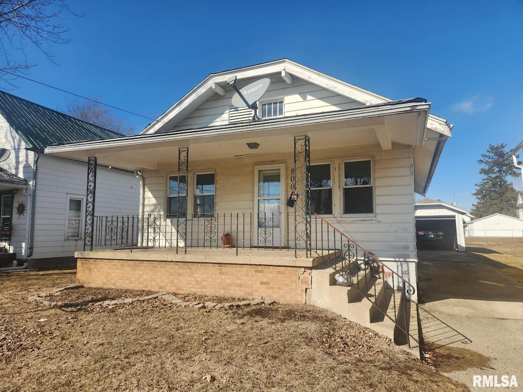 bungalow with a porch and an outdoor structure