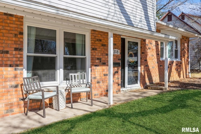 doorway to property featuring brick siding