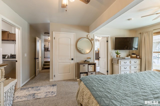 carpeted bedroom featuring washing machine and clothes dryer, ceiling fan, and baseboards