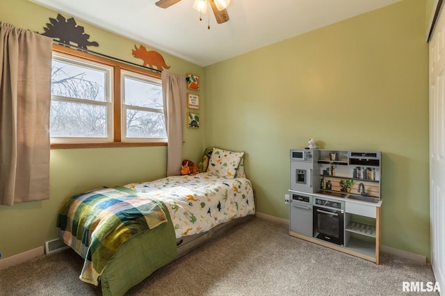 carpeted bedroom featuring a ceiling fan, visible vents, and baseboards