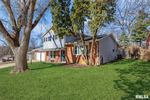 view of front facade with a front yard, concrete driveway, and brick siding