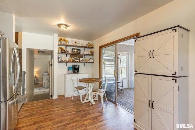 kitchen featuring open shelves, wood finished floors, and stainless steel refrigerator with ice dispenser