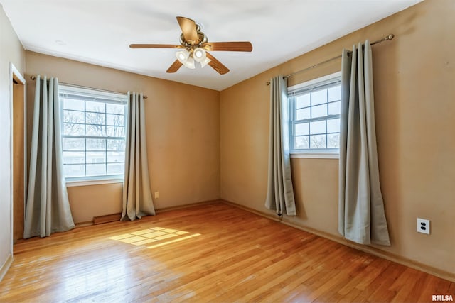 empty room featuring light wood finished floors and a ceiling fan