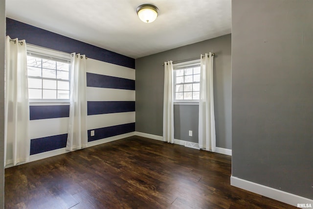 empty room with baseboards and wood finished floors