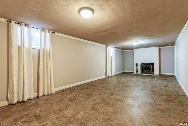 unfurnished living room featuring a textured ceiling, a fireplace, baseboards, and ornamental molding