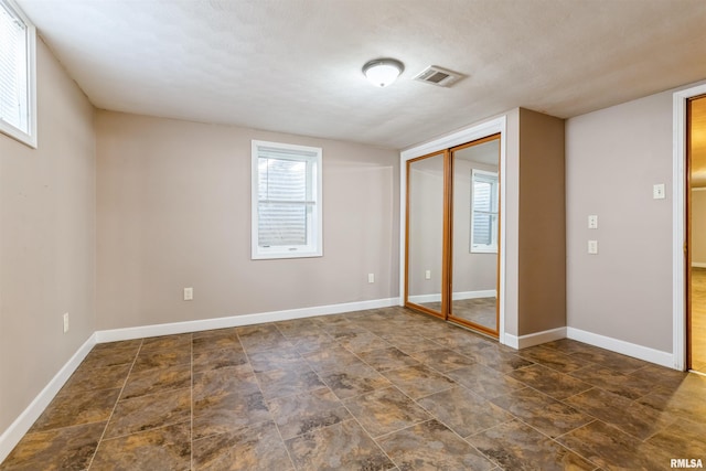 unfurnished bedroom featuring a closet, visible vents, and baseboards