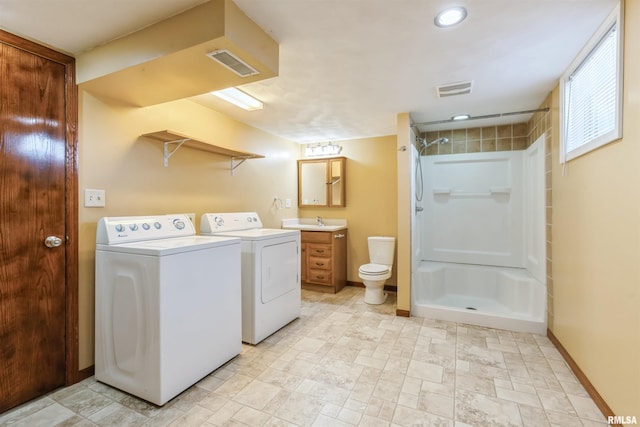 washroom featuring baseboards, visible vents, laundry area, a sink, and washer and dryer