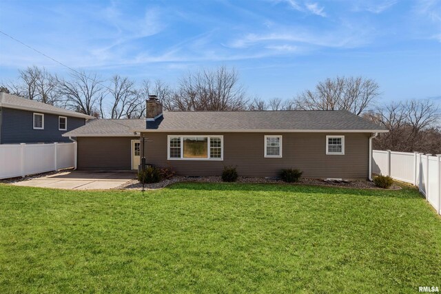 rear view of house featuring a patio, a yard, a fenced backyard, and a chimney