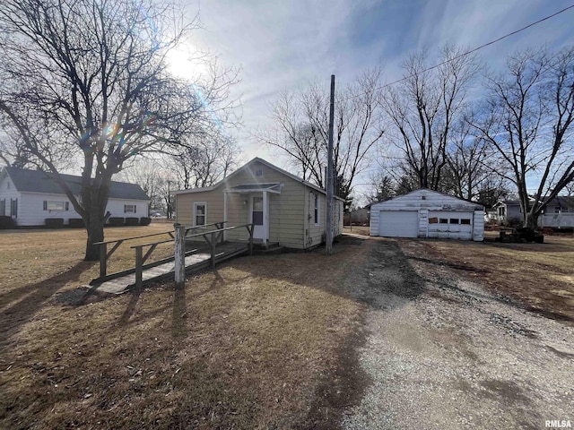 bungalow-style house with a detached garage and an outbuilding