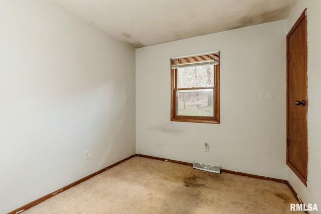 unfurnished room featuring baseboards, visible vents, and light carpet