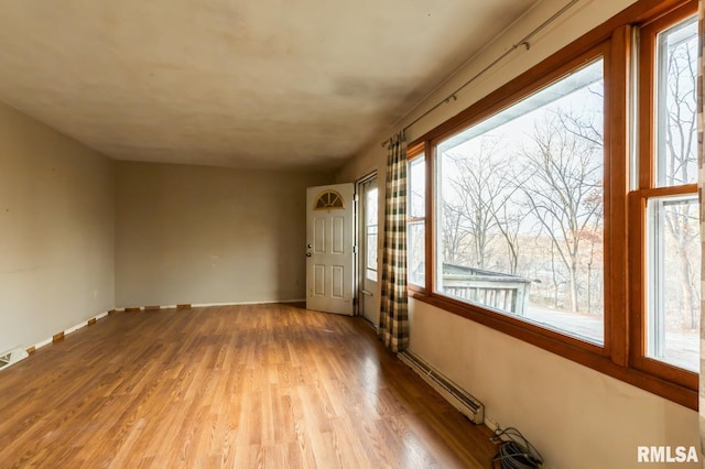 interior space featuring light wood-type flooring, baseboards, baseboard heating, and visible vents