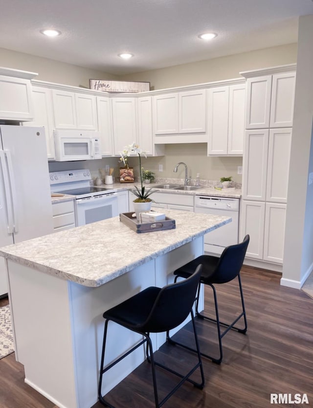 kitchen with white cabinetry, white appliances, dark wood-style floors, and a sink