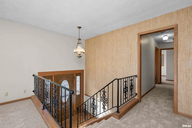 interior space featuring an upstairs landing, baseboards, and carpet floors