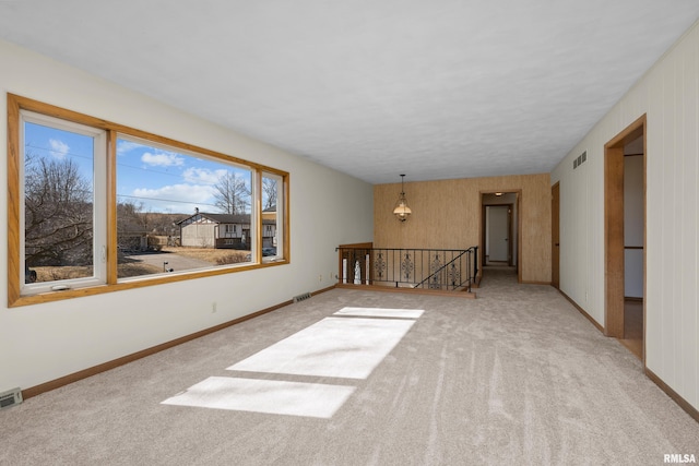 carpeted empty room with visible vents and baseboards