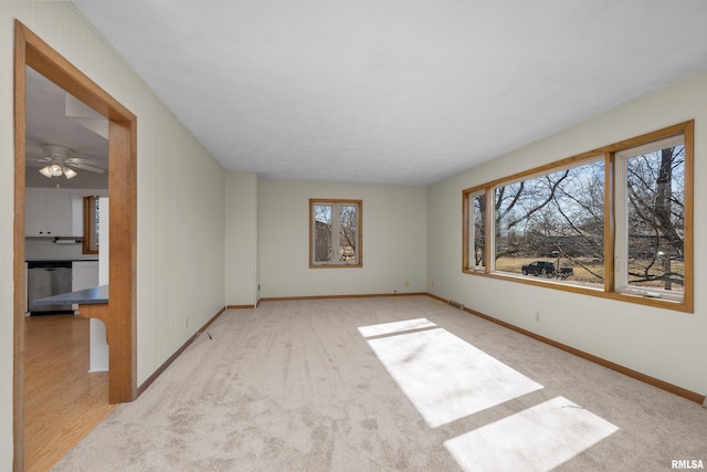 spare room with visible vents, carpet, and baseboards