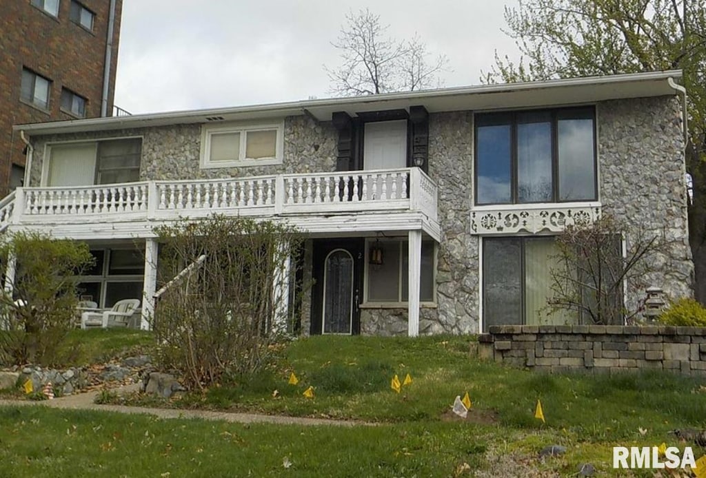 view of front of property with stone siding and a front lawn