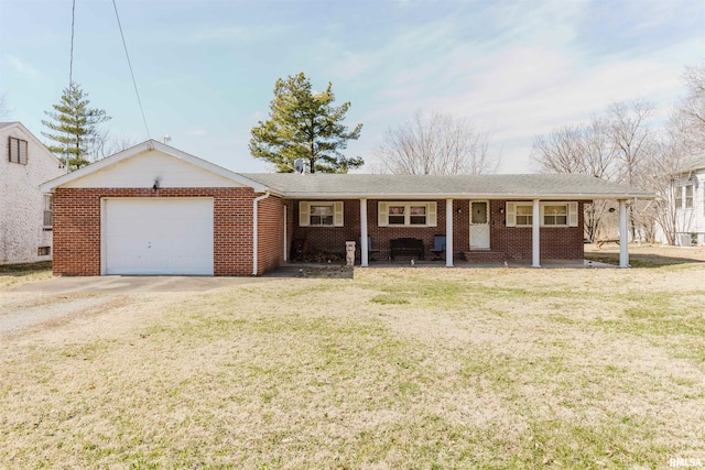 single story home featuring brick siding, a front lawn, a porch, a garage, and driveway