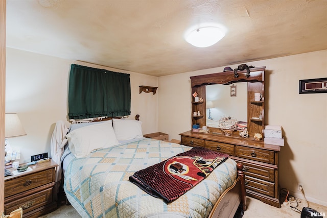 bedroom with baseboards and light carpet