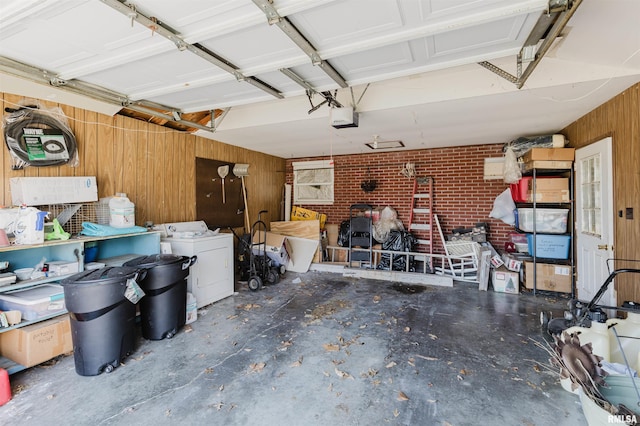 garage featuring wooden walls, washer / dryer, and a garage door opener