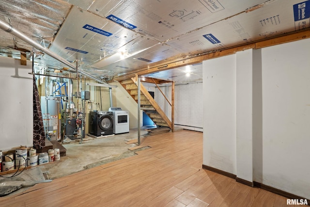 unfinished below grade area with washer and dryer, wood finished floors, water heater, stairway, and a heating unit