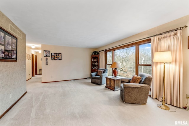 sitting room featuring visible vents, baseboards, and light carpet