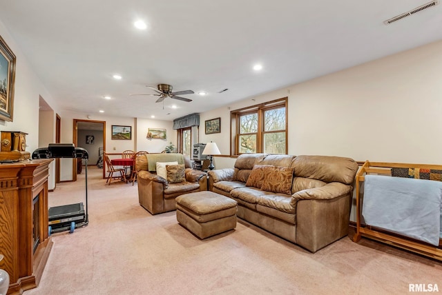 living area with recessed lighting, visible vents, and light carpet