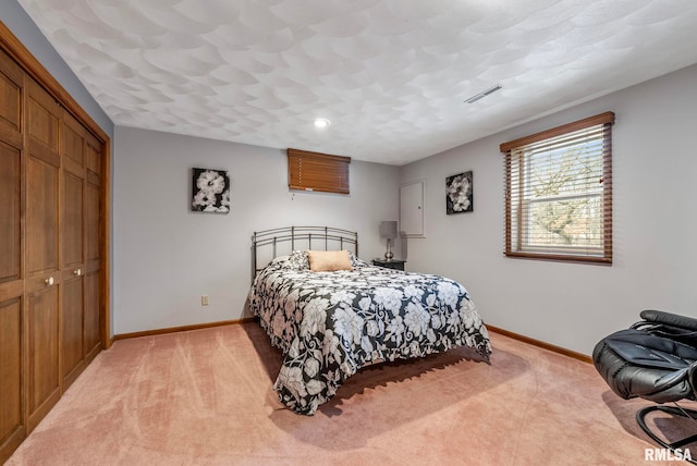 bedroom with light colored carpet, visible vents, a closet, and baseboards