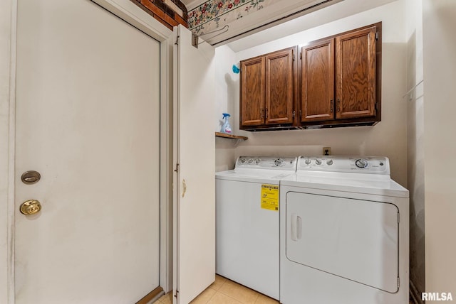 laundry room featuring separate washer and dryer, light tile patterned floors, and cabinet space