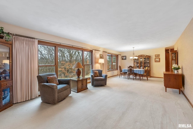 living room featuring light colored carpet, baseboards, and an inviting chandelier