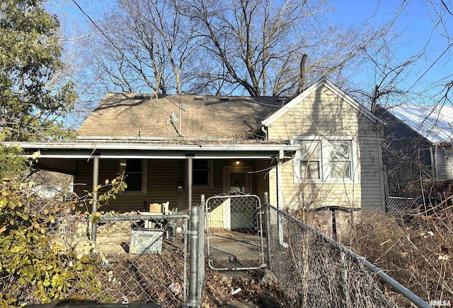 rear view of property with a porch, a gate, fence, and a shingled roof