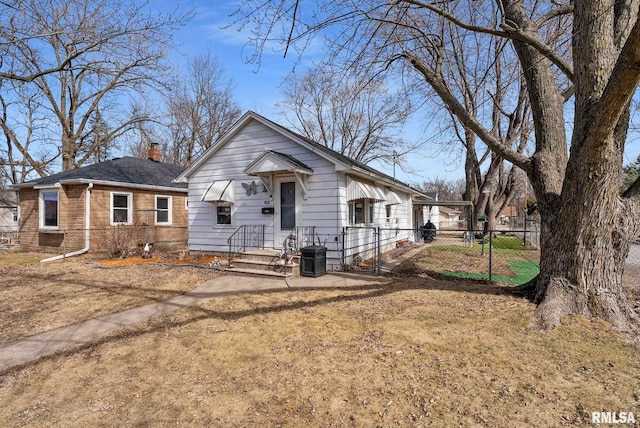 view of front of house featuring cooling unit, fence, brick siding, and a chimney