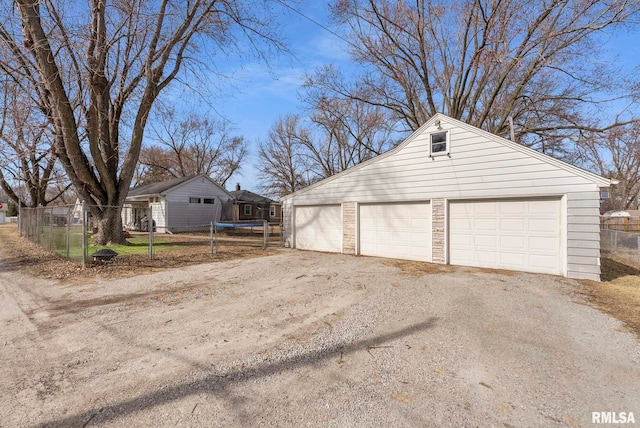 detached garage with a trampoline and fence