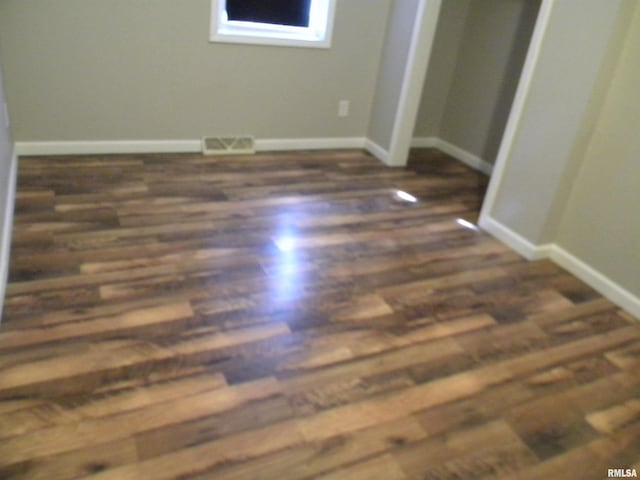 unfurnished bedroom featuring visible vents, baseboards, and wood finished floors