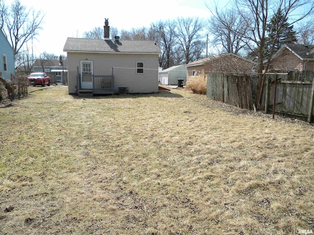 rear view of property featuring cooling unit, a lawn, a deck, and fence