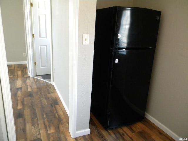 corridor featuring wood finished floors and baseboards