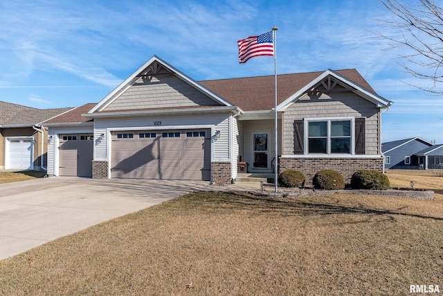 craftsman house with a front yard, an attached garage, brick siding, and driveway