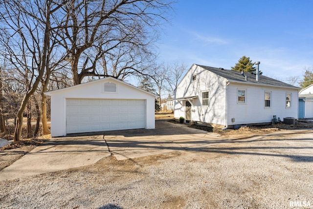 view of side of property featuring an outbuilding, cooling unit, and a garage