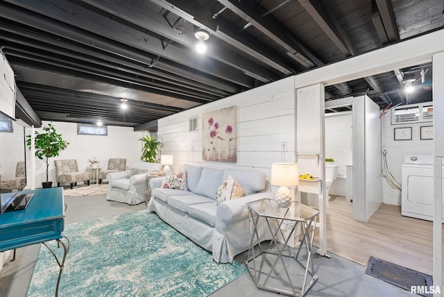 living area featuring washer / dryer and concrete floors