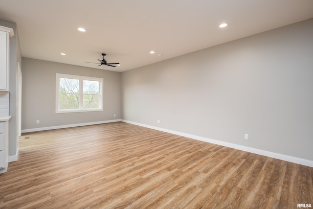 spare room featuring light wood-style flooring, recessed lighting, baseboards, and ceiling fan