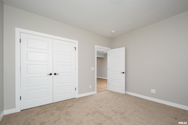 unfurnished bedroom with a closet, carpet flooring, and baseboards