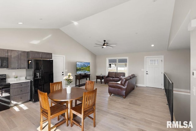 dining space with light wood-type flooring, baseboards, high vaulted ceiling, and ceiling fan