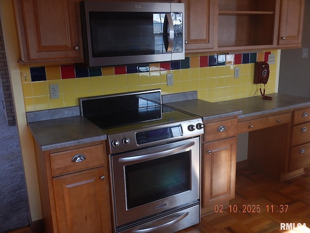 kitchen featuring brown cabinets, open shelves, dark countertops, backsplash, and stainless steel appliances