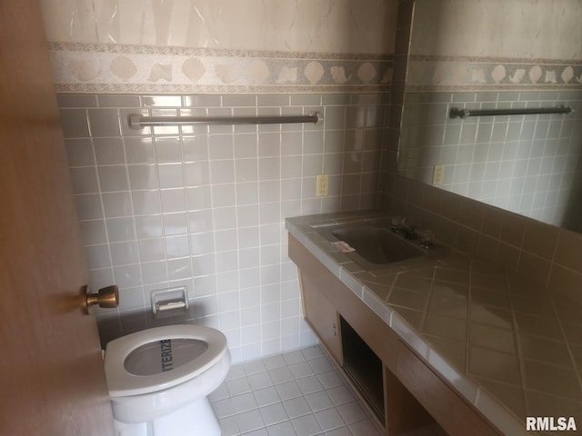 half bath featuring tile walls, vanity, and wallpapered walls