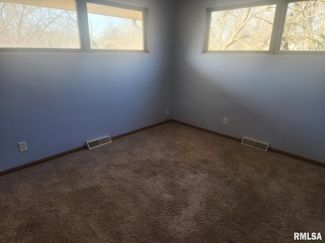 carpeted empty room with visible vents and baseboards