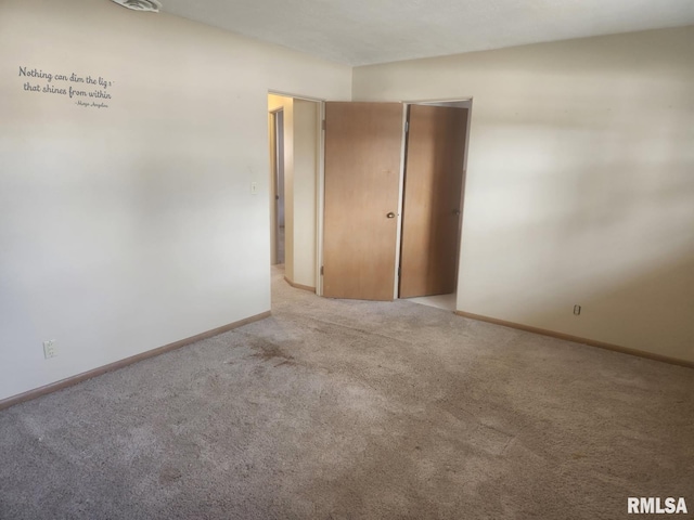 carpeted empty room featuring baseboards