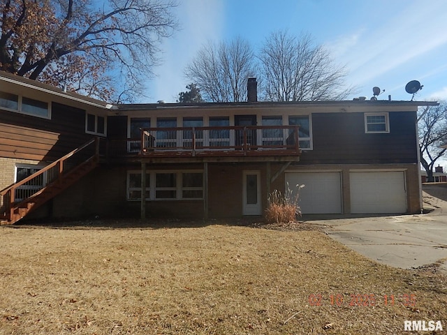 back of property with driveway, stairway, a garage, brick siding, and a chimney