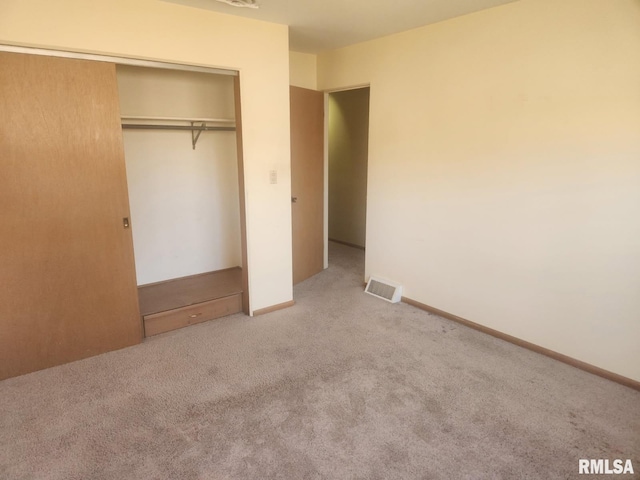 unfurnished bedroom featuring visible vents, baseboards, a closet, and carpet flooring