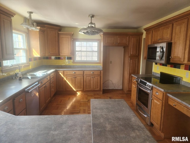 kitchen with stainless steel appliances, plenty of natural light, and brown cabinetry