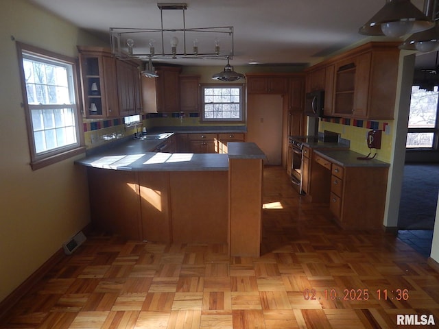 kitchen with visible vents, stainless steel range with electric stovetop, open shelves, dark countertops, and a peninsula